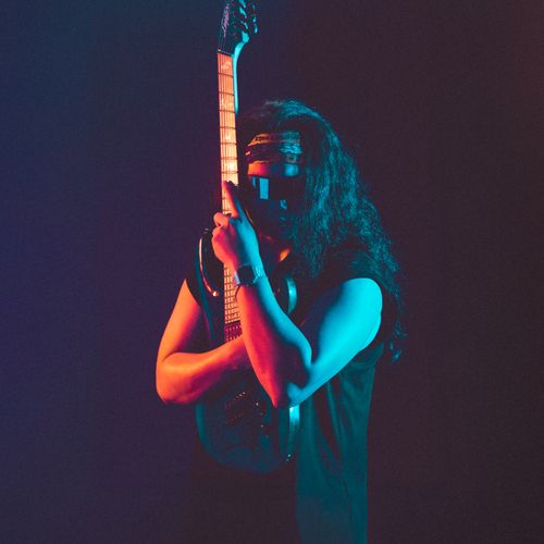 Free Dramatic neon-lit portrait of a guitarist in Hà Nội showcasing rock style and attitude. Stock Photo