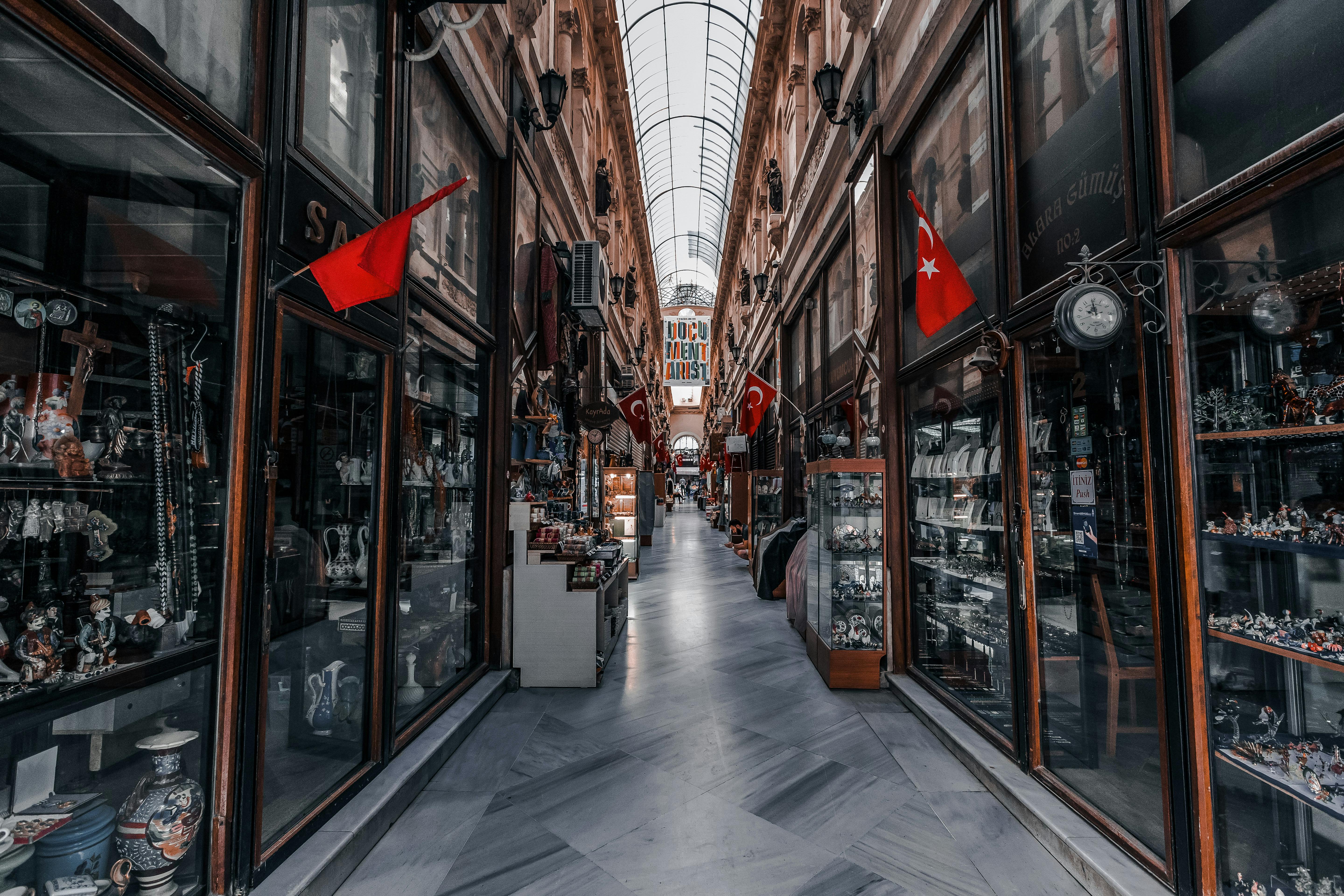 Explore the vibrant covered bazaar in Istanbul's historic Beyoğlu with flags and boutique shops.