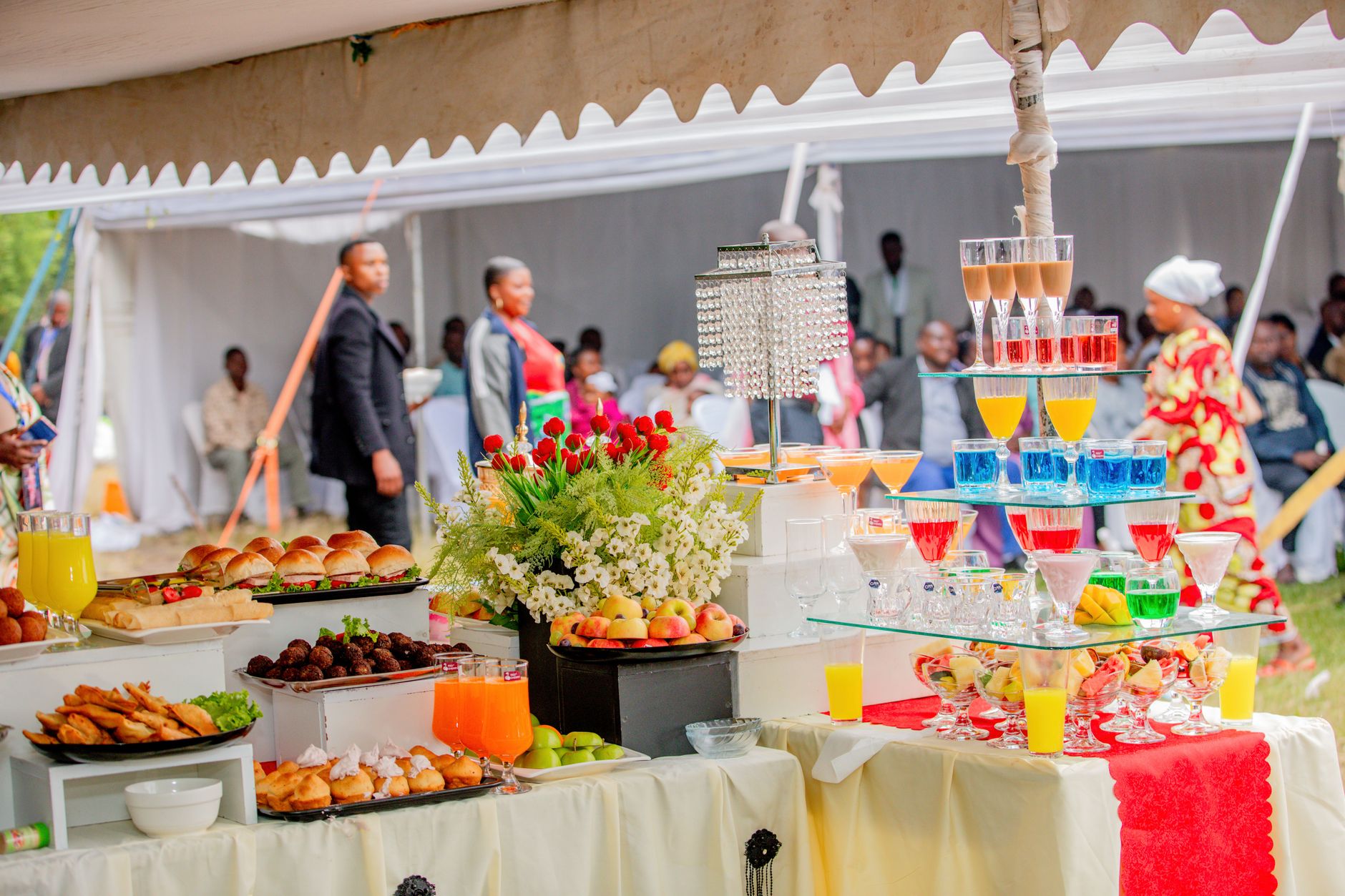 Colorful buffet arrangement at an outdoor event featuring drinks and snacks.