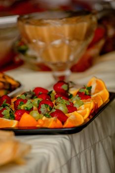 Delicious fruit platter featuring fresh strawberries, oranges, and grapes in a vibrant arrangement.