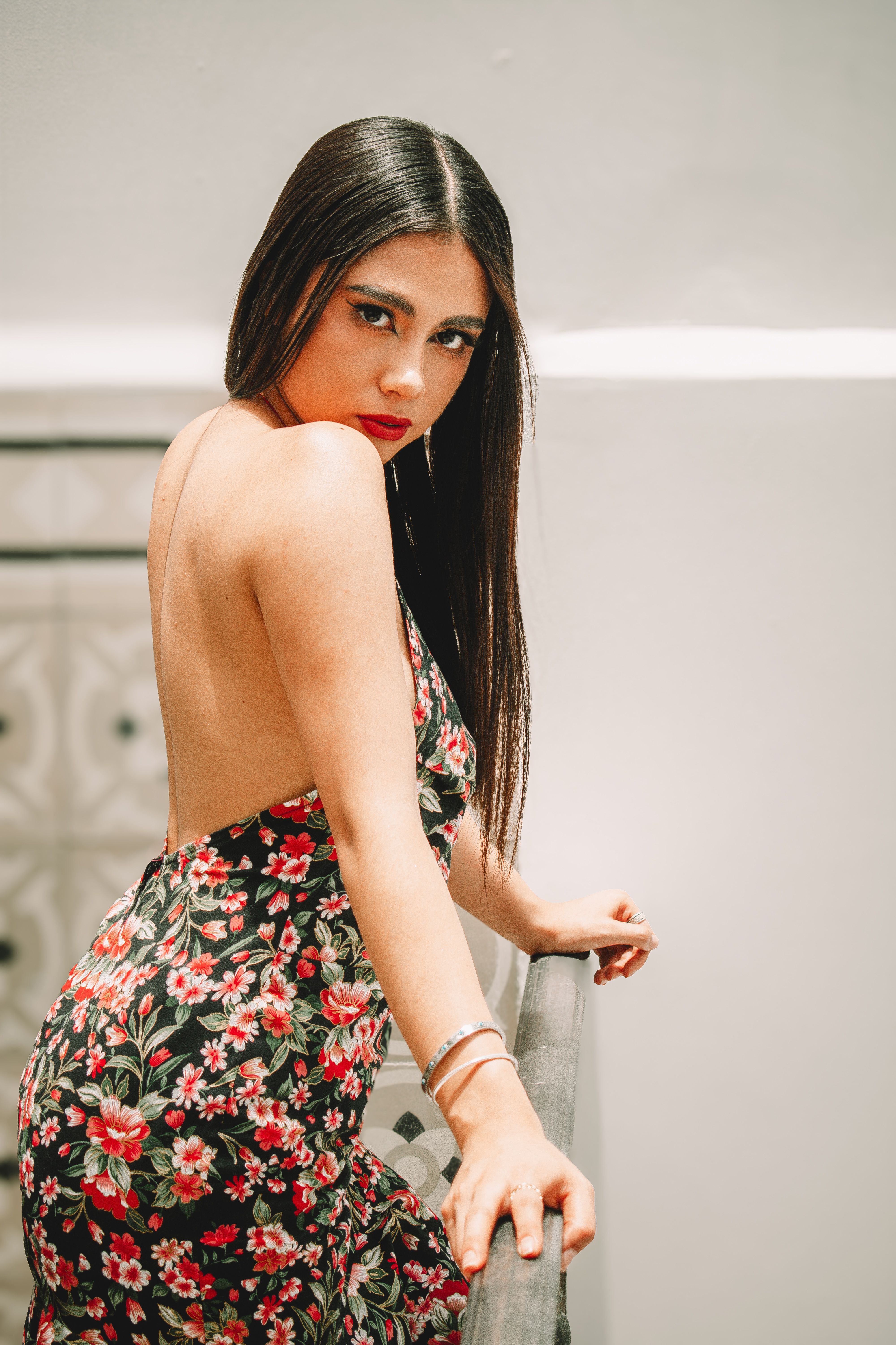 Woman in a floral dress on a balcony, casual spring style