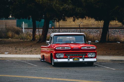 Free A vibrant red classic Chevrolet truck parked outdoors, perfect for vintage car enthusiasts. Stock Photo