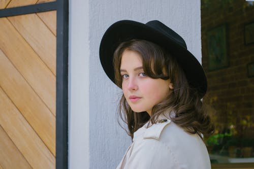 Chic portrait of a young woman wearing a black hat, embodying modern elegance and style.