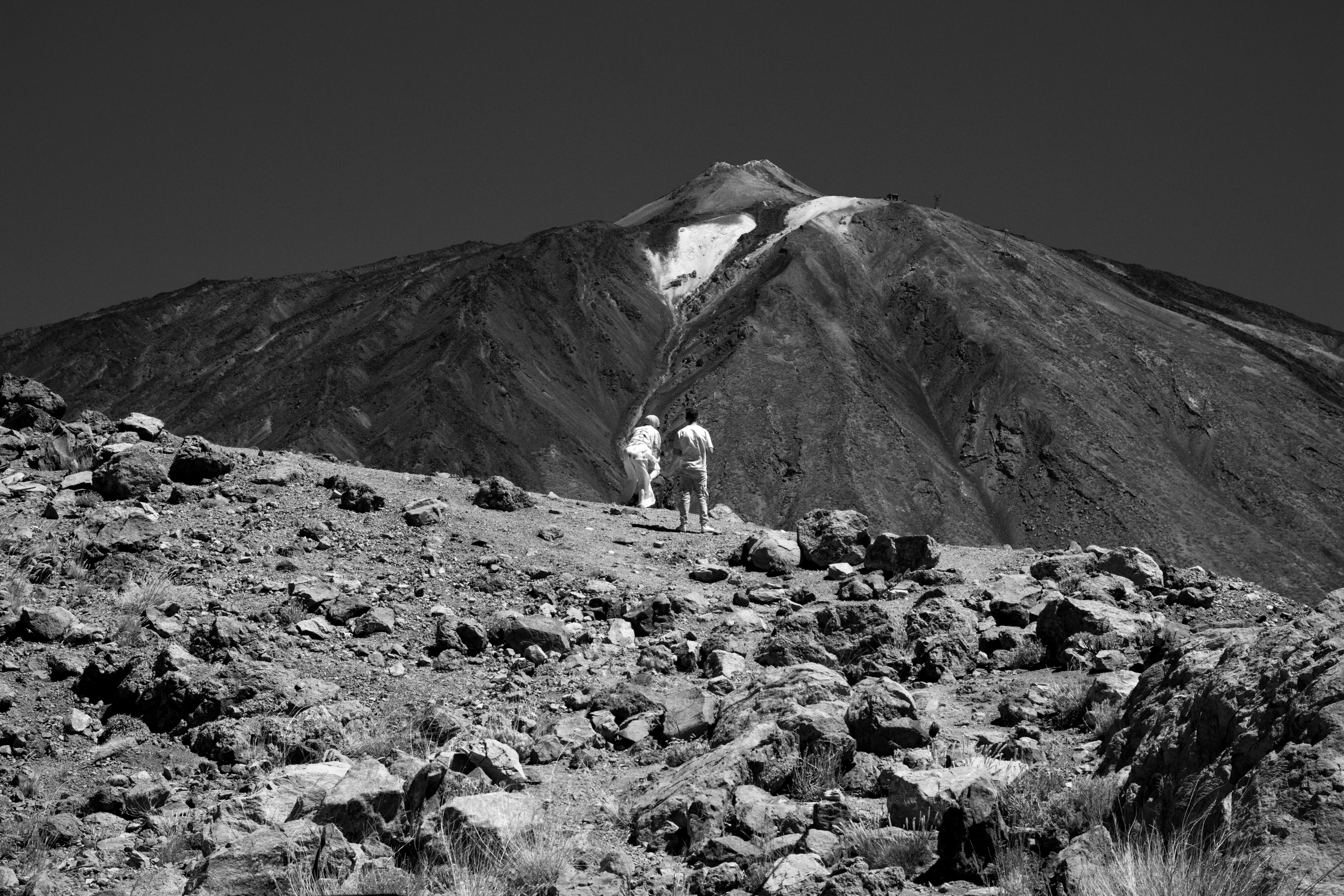 Hikers Exploring Black and White Volcanic Landscape · Free Stock Photo