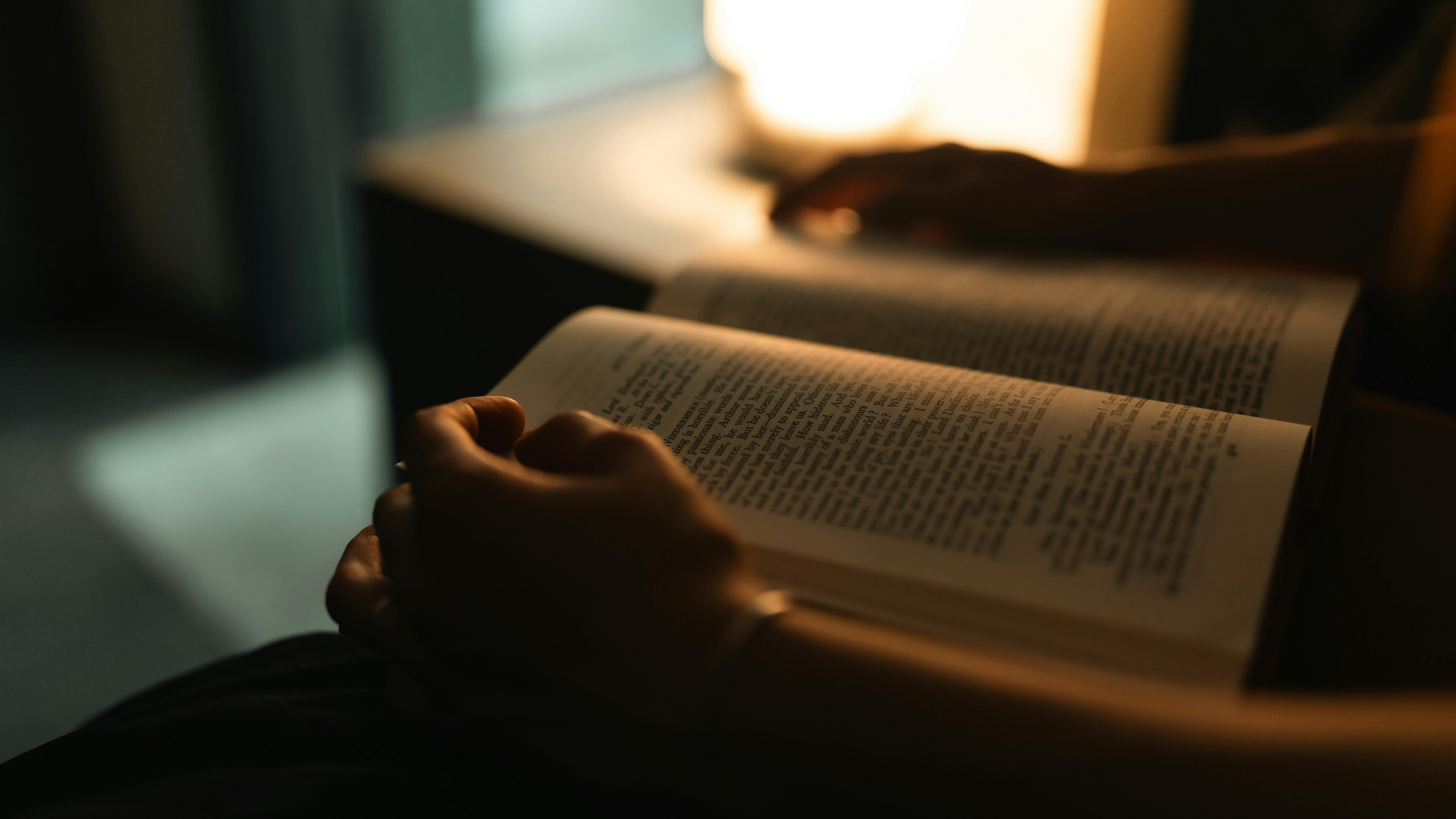 Reading before bed under a warm bedside lamp — low-glare, melatonin-friendly evening lighting