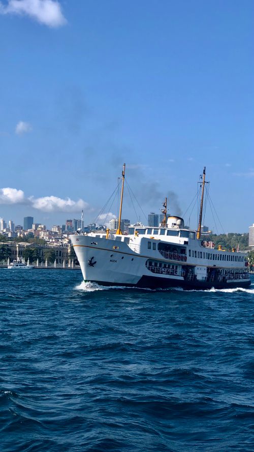Free A vintage ferry cruising the Bosphorus with Istanbul's skyline in the background. Stock Photo