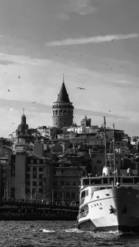 Black and white photograph of İstanbul's skyline featuring Galata Tower and a ferry on the Bosphorus.