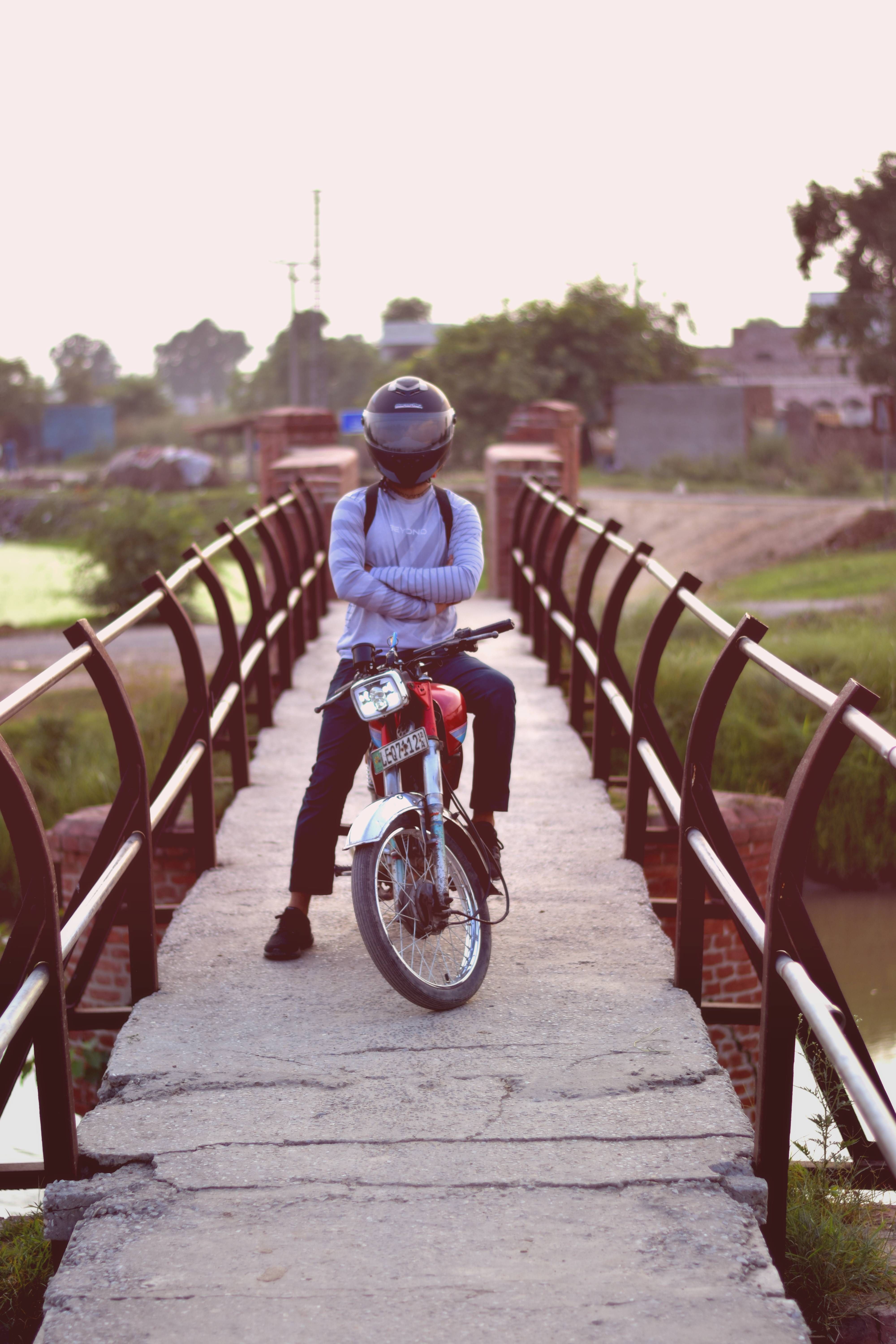 Person on Motorcycle Riding Across Rustic Bridge · Free Stock Photo