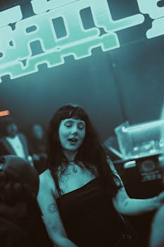 A woman enjoying the nightlife at a vibrant, neon-lit nightclub.