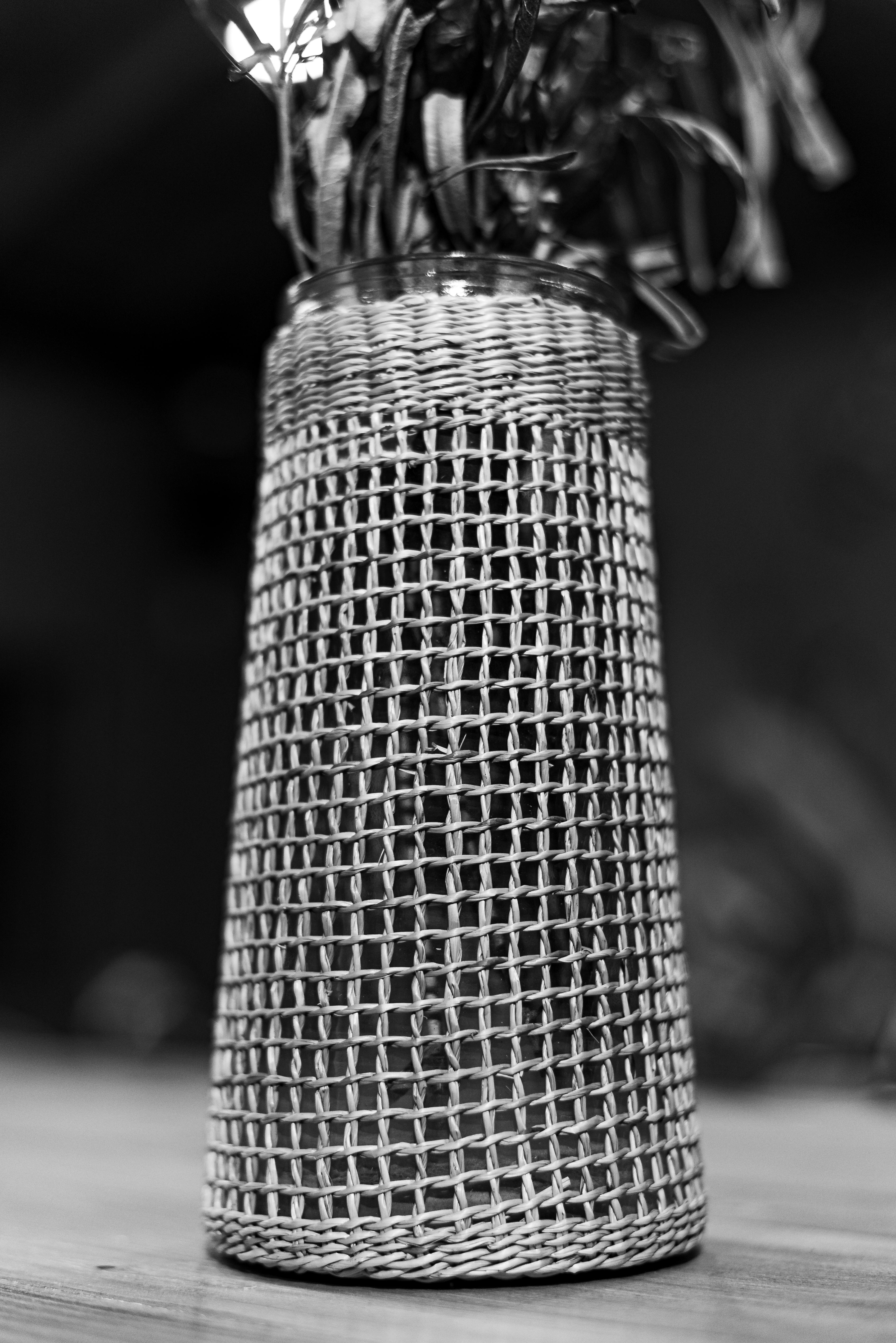 Free An artistic black and white photo of a woven basket with dry leaves, emphasizing texture and contrast. Stock Photo