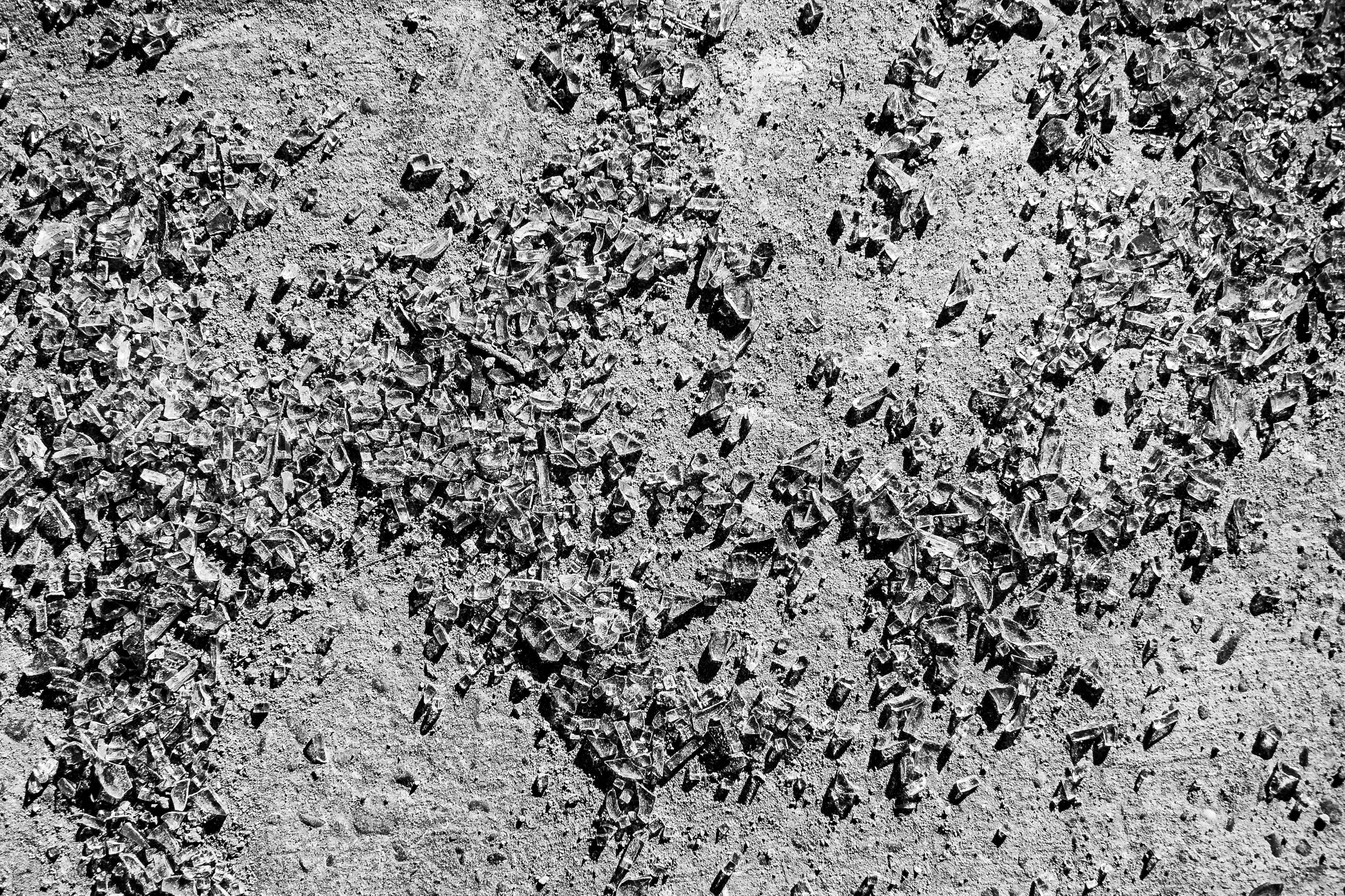 Black and white image of shattered glass on urban pavement in Bahía Blanca, Argentina.