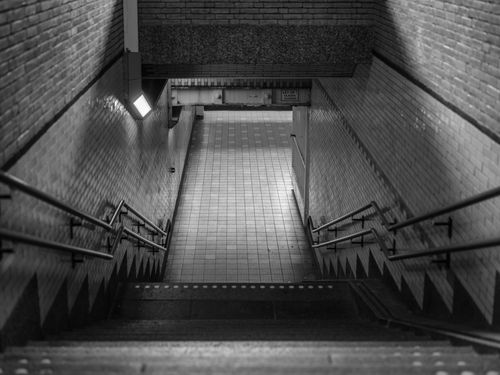 Free Black and white photo of a symmetrical underground staircase with mosaic tiles in Bussum, Netherlands. Stock Photo