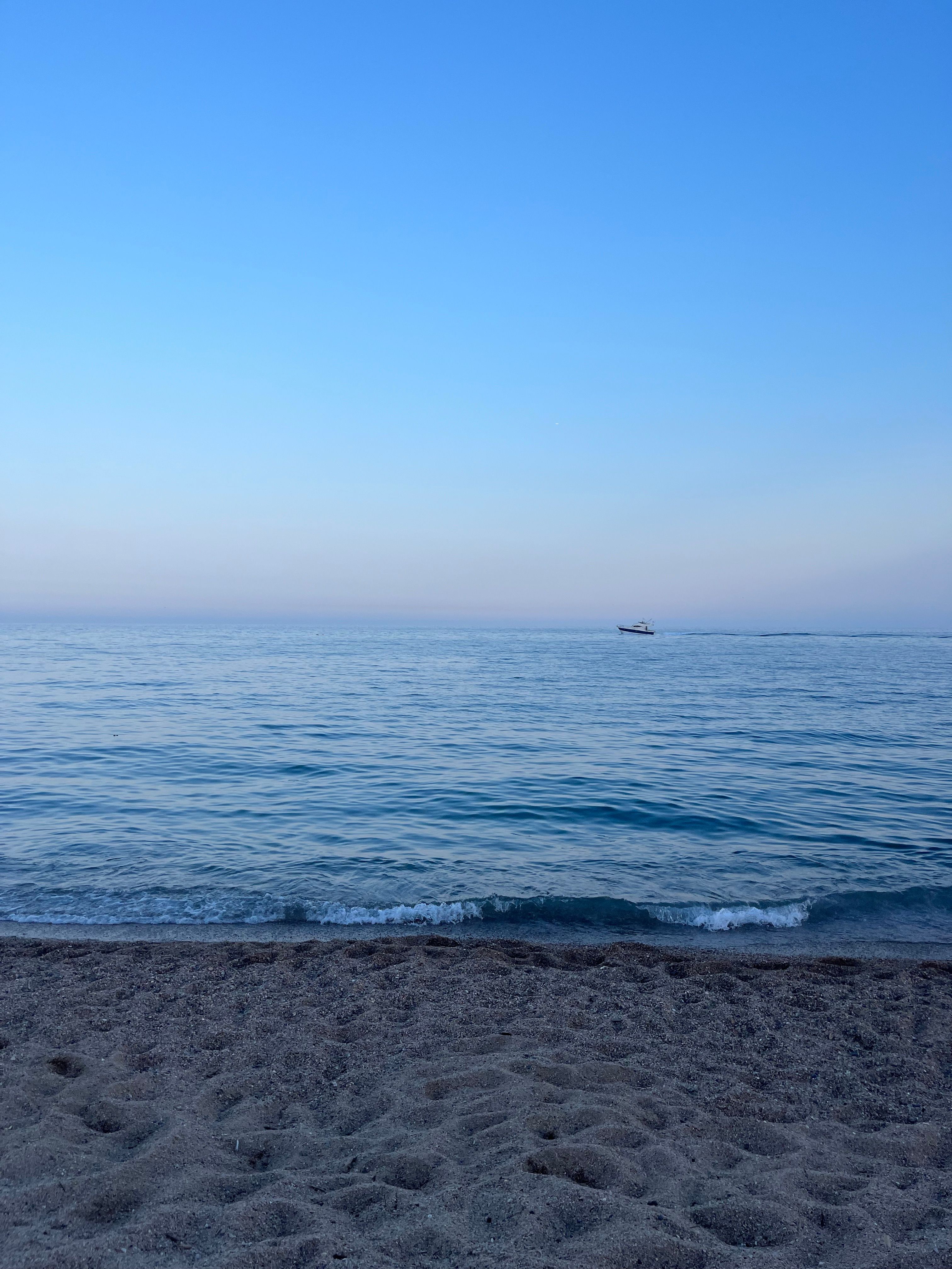 Peaceful view of a tranquil beach with gentle waves in Santa Susanna, Spain.