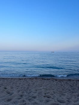 Peaceful view of a tranquil beach with gentle waves in Santa Susanna, Spain.