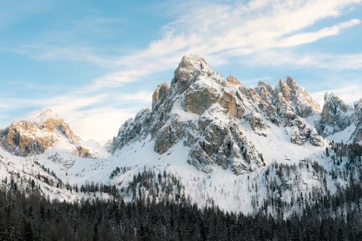Stunning snow-covered Dolomite peaks under a bright blue sky, showcasing winter's beauty.