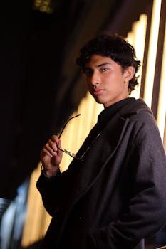 Portrait of a stylish young man with glasses in San Isidro, Lima, at night.
