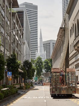 City street with a mix of modern skyscrapers and historical buildings under a clear sky.