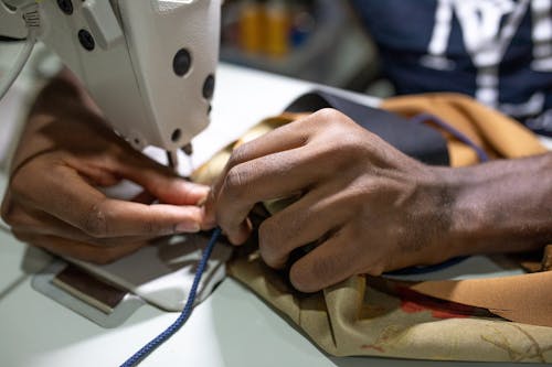 Free Person Putting Thread Through A Needle Of A Sewing Machine Stock Photo