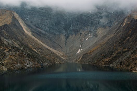 Stunning view of a tranquil lake nestled in the rugged Andes mountains in Cuzco, Peru.