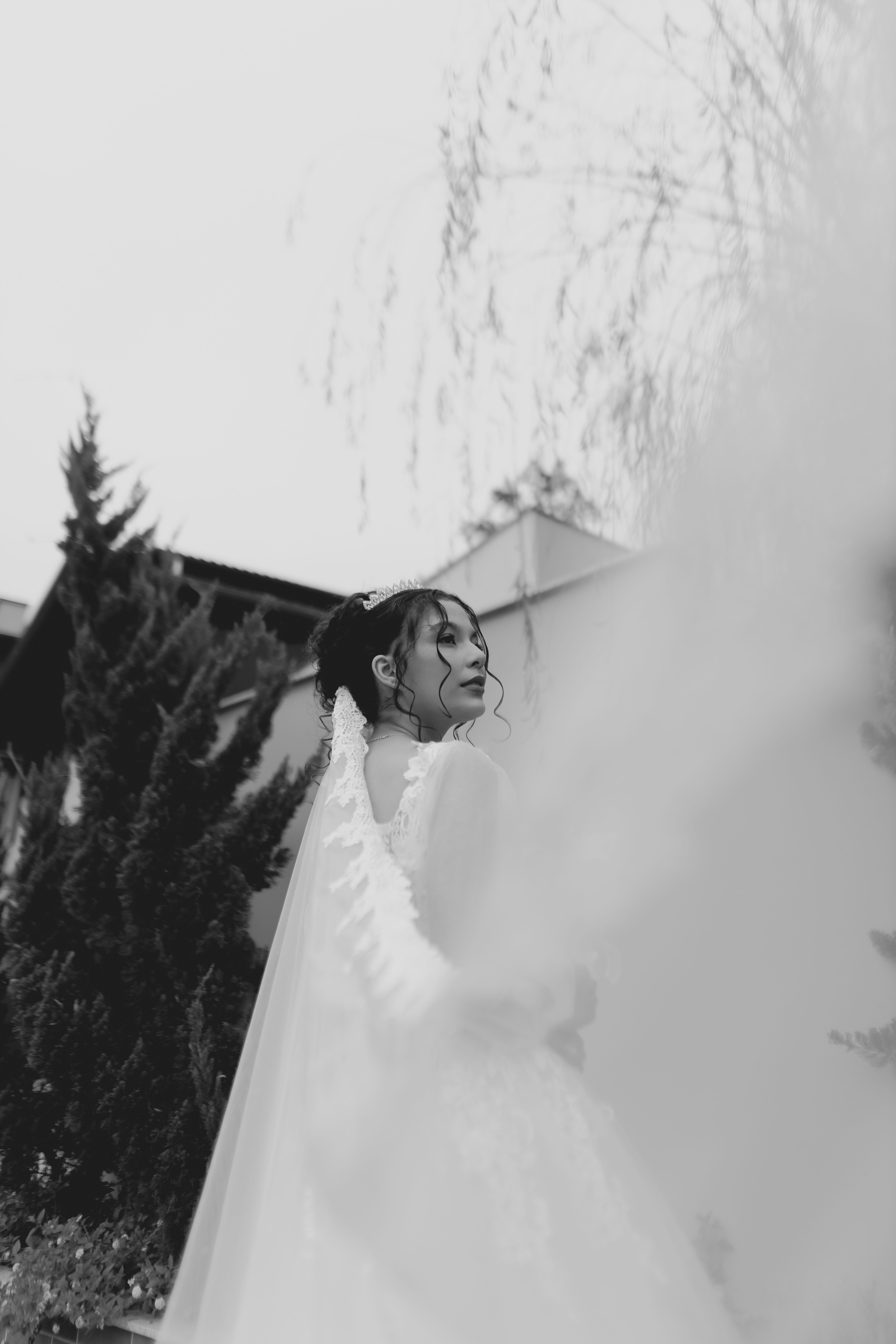 Black and white portrait of a bride outdoors, showcasing elegance and timeless beauty.
