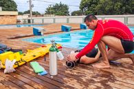 Lifeguard providing emergency care to a swimmer by a swimming pool in Mato Grosso, Brazil.