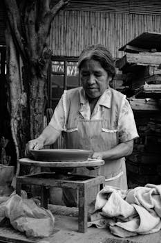 An artisan skillfully crafts pottery in Oaxaca, highlighting Mexican craftsmanship.