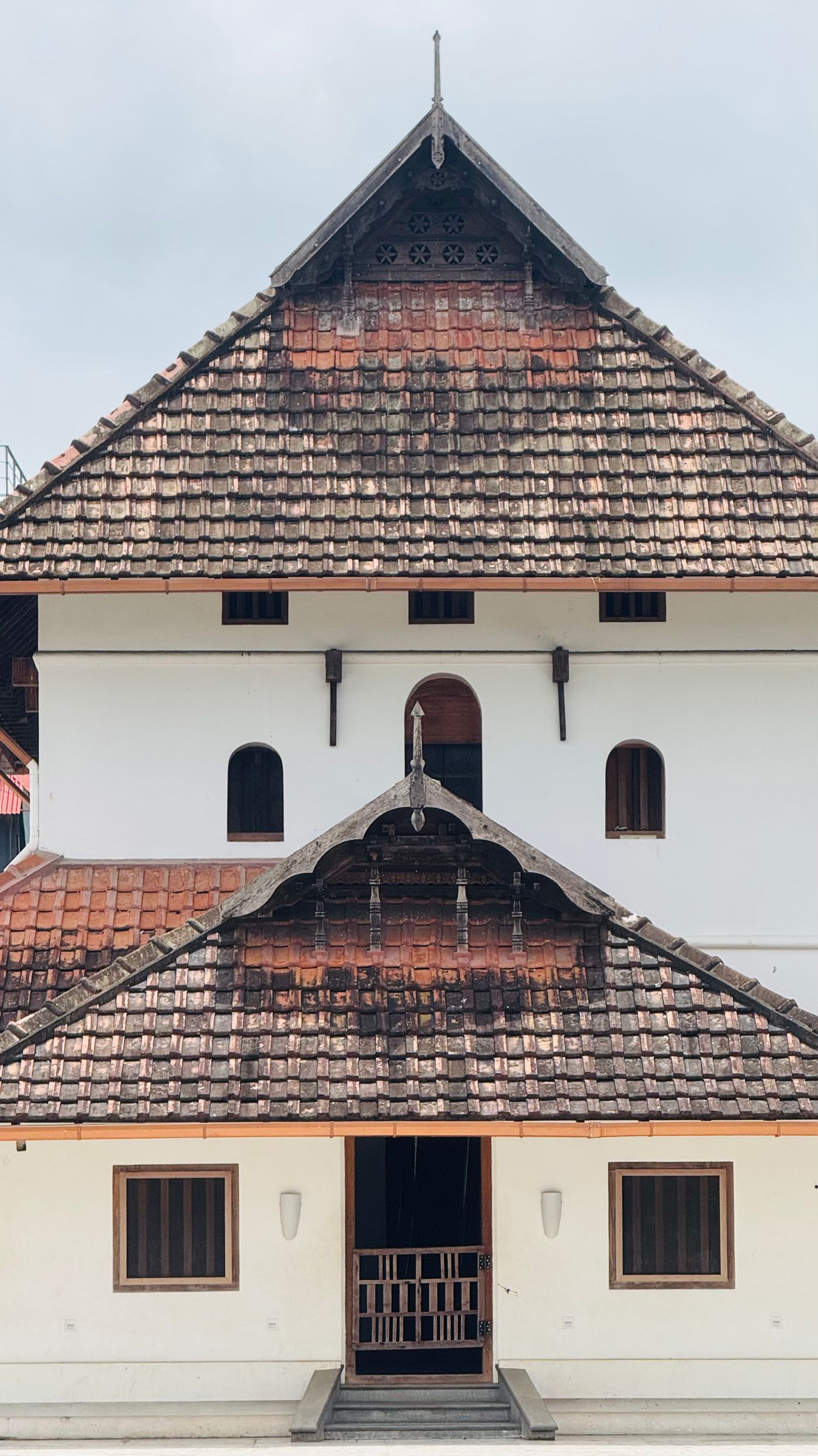 Tiled gable and carved timber of an old South Indian house — representative image