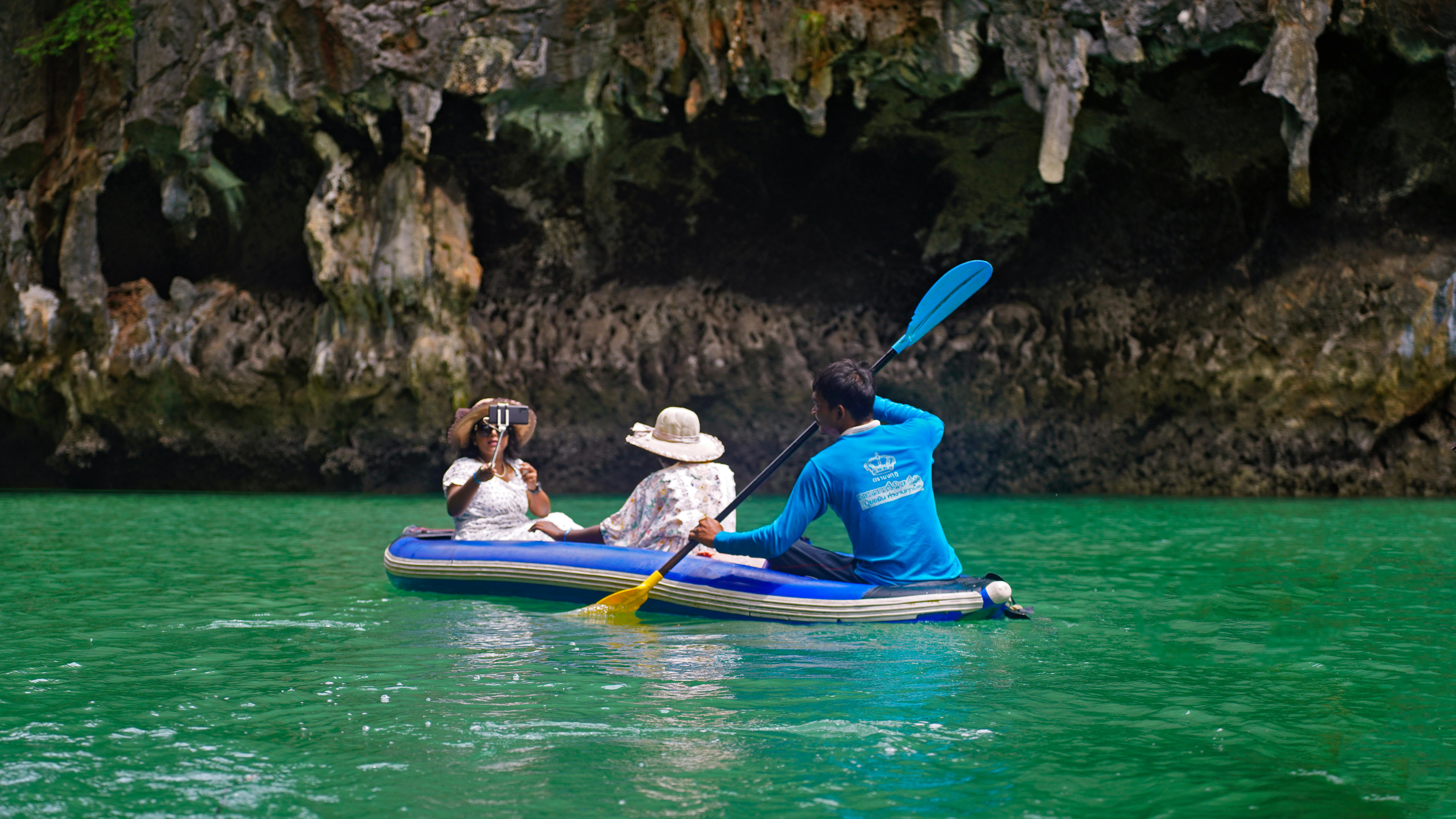 Group kayaking through stunning limestone caves in Krabi, Thailand.
