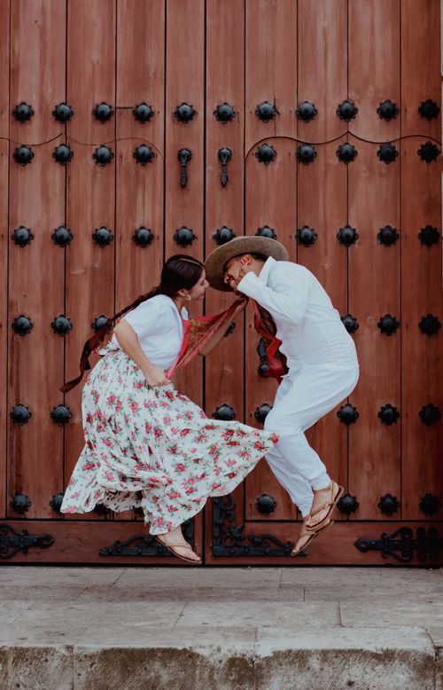Free Vibrant dancers in traditional Oaxacan attire express joy against a rustic wooden backdrop. Stock Photo