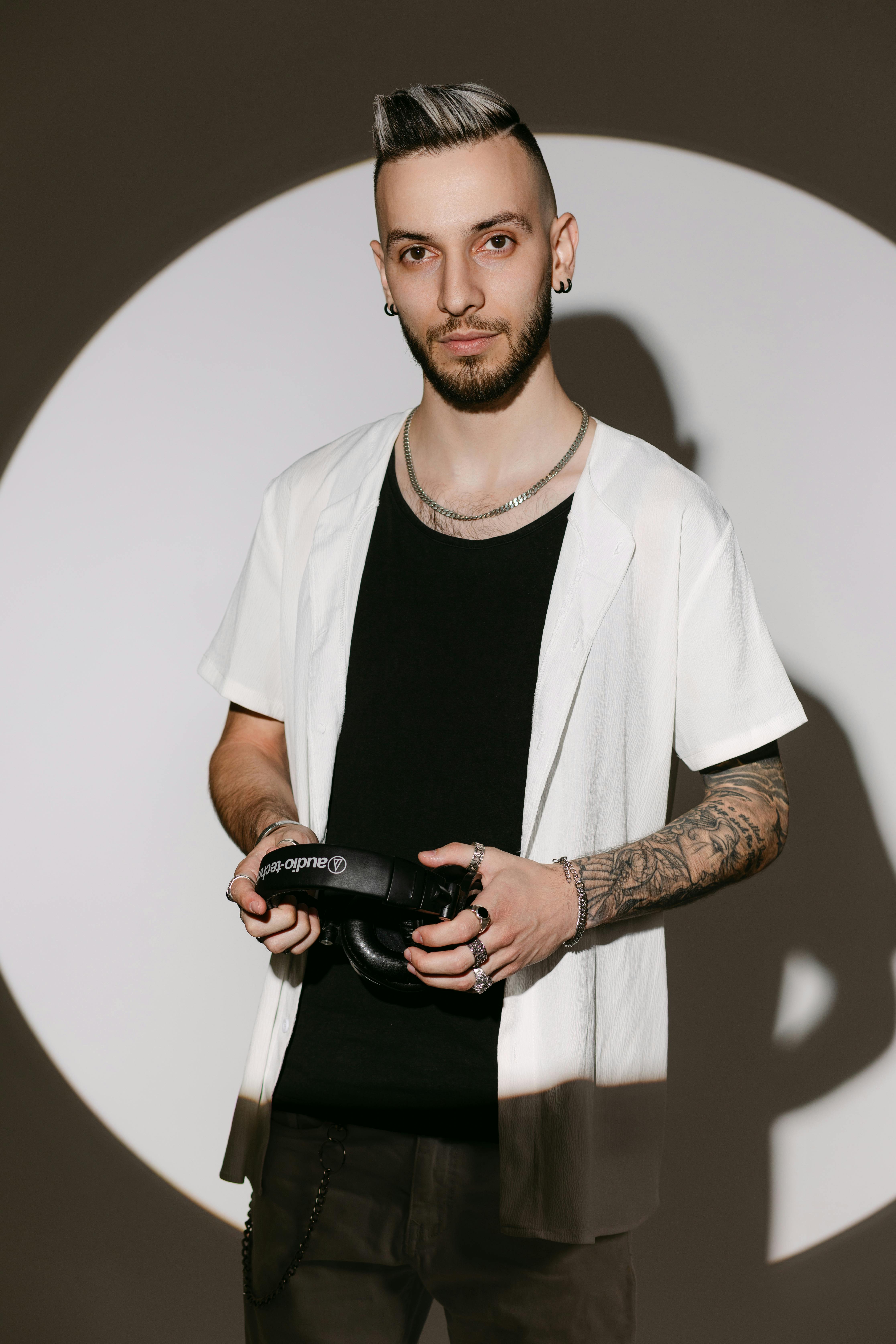 Stylish young man with headphones in a studio setting exuding modern vibe.