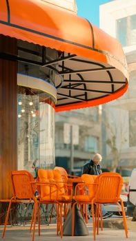 Bright orange seating under a vibrant awning at a café in Yalova, Türkiye, capturing a lively morning scene.