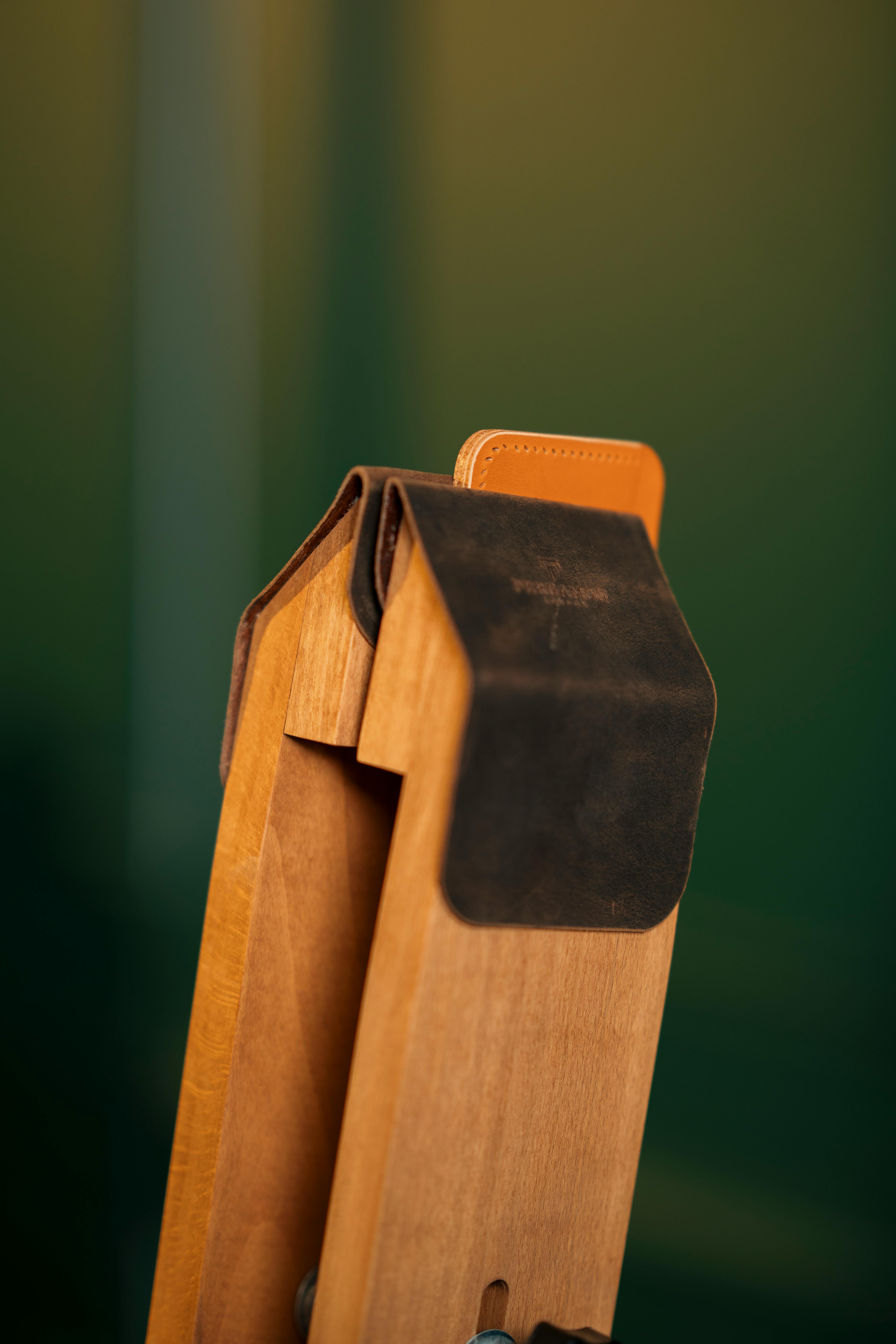Gratis Primo piano di un cavalletto in legno con dettagli in pelle su sfondo verde, che mette in risalto la maestria artigianale. Foto a disposizione