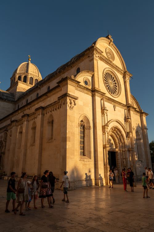 Free A beautiful capture of St. James Cathedral in Šibenik, Croatia, during sunset with people walking by. Stock Photo