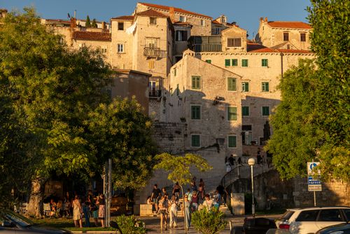 Free Sunset view of people by historic buildings in Šibenik, Croatia, highlighting its stunning medieval architecture. Stock Photo