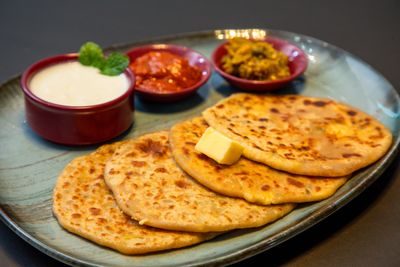 Indian paratha served with yogurt and pickles
