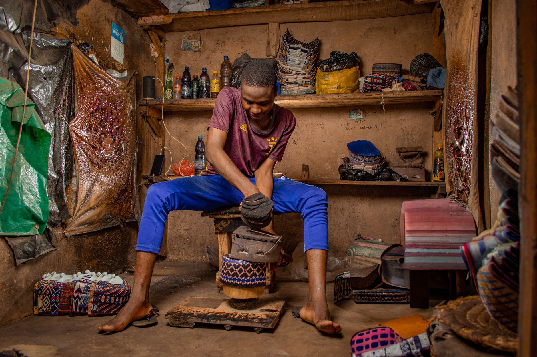 Nigerian artisan skillfully crafting shoes in a traditional workshop in Kano, Nigeria.