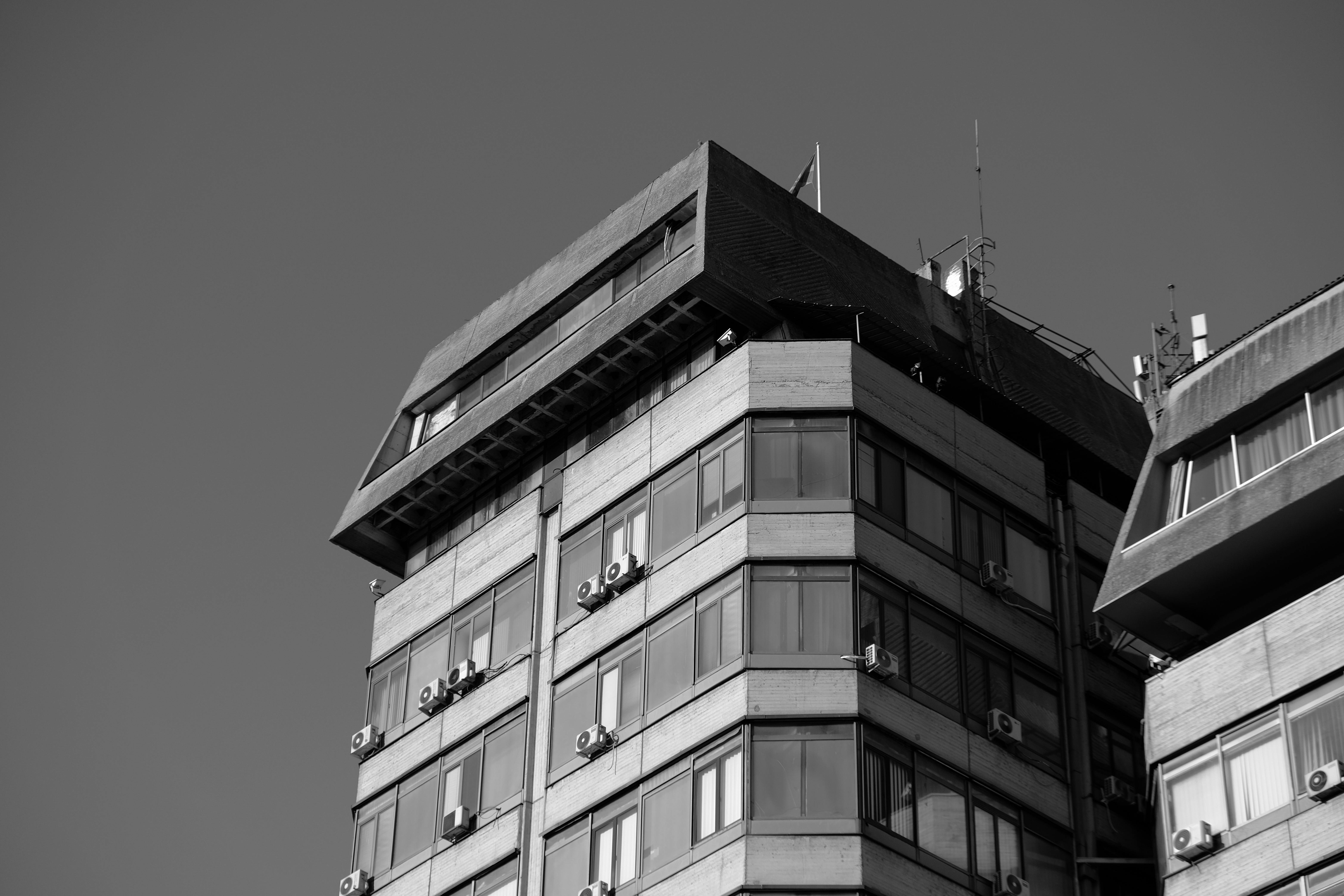 Zadarmo Čiernobiela fotografia exteriéru modernej kancelárskej budovy, ktorá prezentuje mestskú architektúru. Fotka z fotobanky