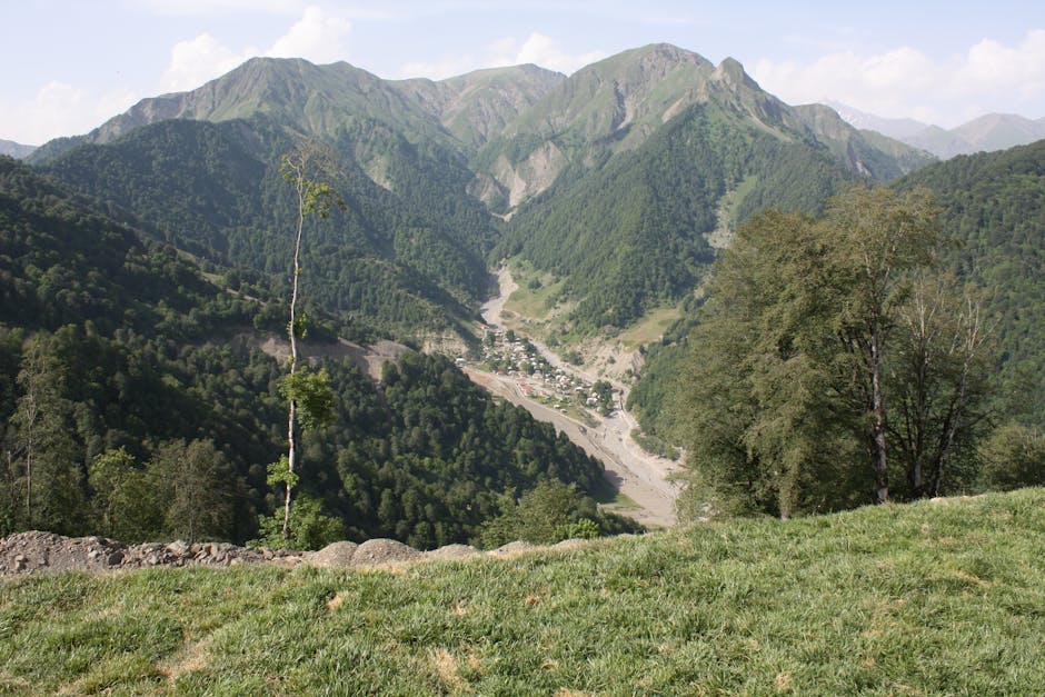A stunning view of lush green mountains with a small village nestled in the valley below.
