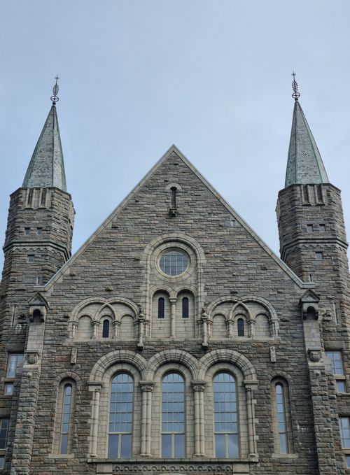 Free Front view of a historic stone cathedral with ornate architecture and twin spires. Stock Photo