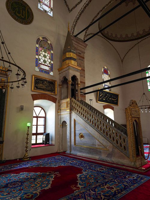 Free Stunning mosque interior with vibrant carpets and intricate minbar details. Stock Photo