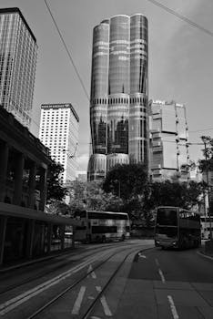Monochrome view of a bustling city street with iconic skyscrapers and buses.