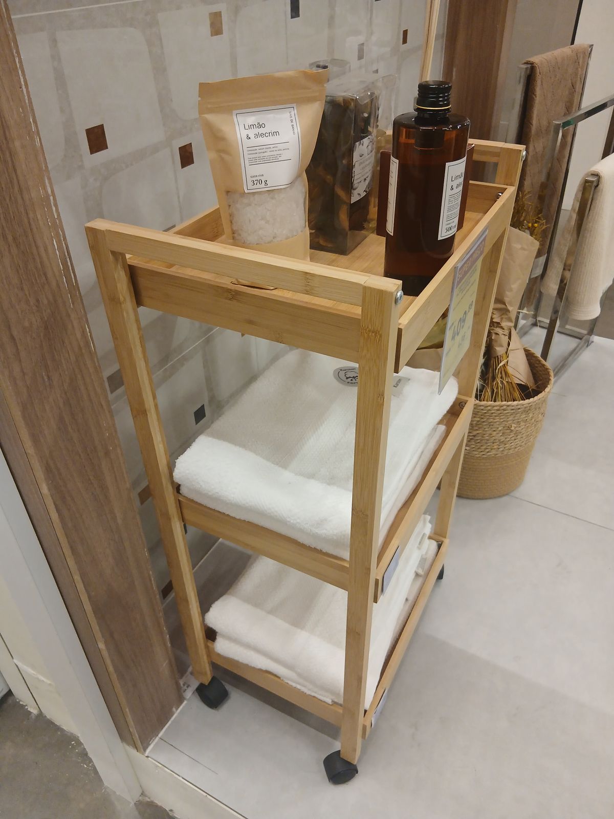 Wooden bathroom organizer with neatly arranged towels and bath essentials