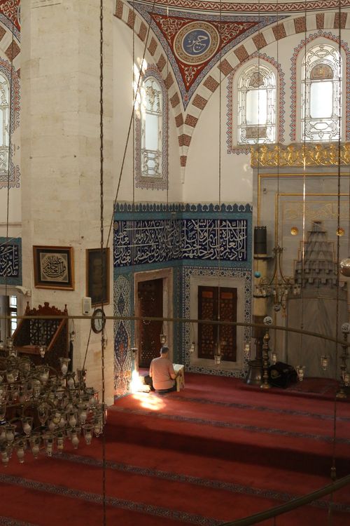 Free A man praying inside a beautifully adorned mosque with intricate architecture. Stock Photo
