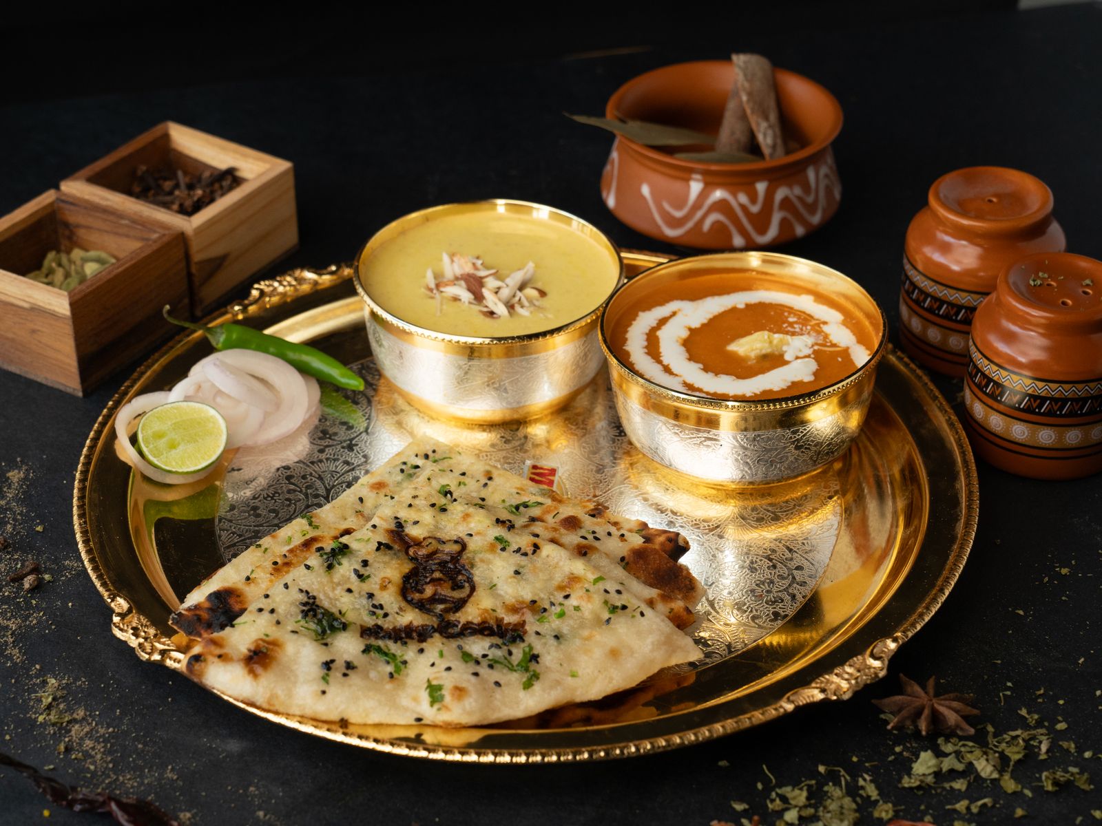 A rich Indian thali spread with dal, curry and naan