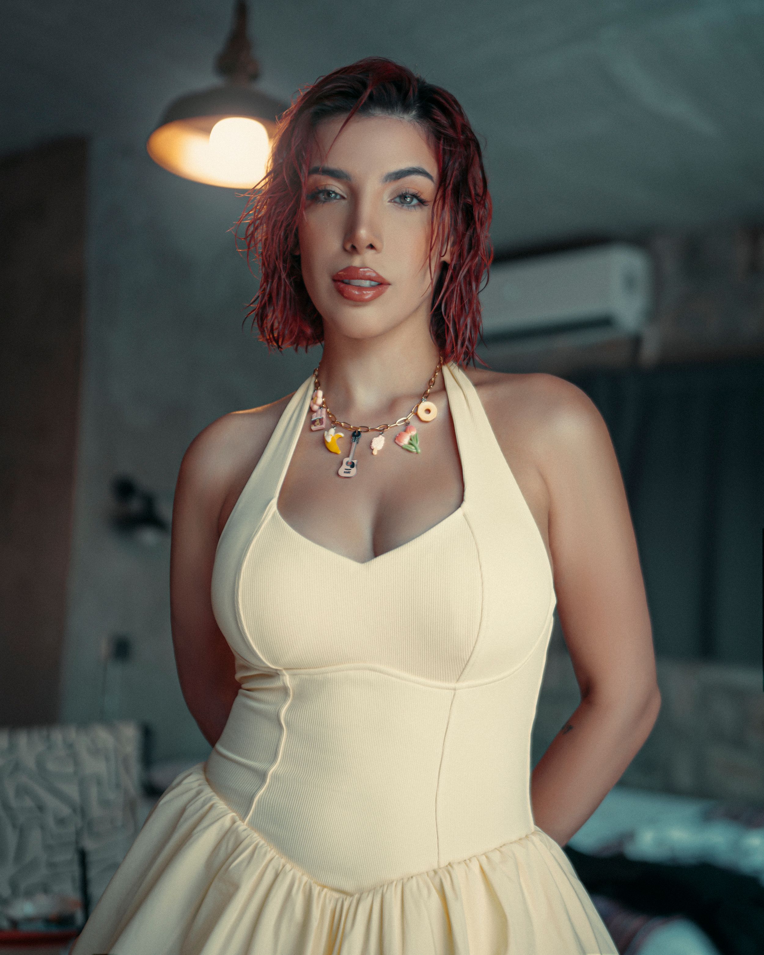 Stunning woman in a fashionable cream dress posing confidently indoors.