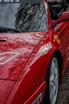 Detailed shot of a red Ferrari showcasing sleek design and racing elements.