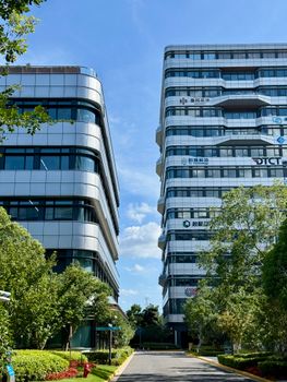 Tall, modern office buildings in a vibrant Shanghai setting under a clear blue sky.