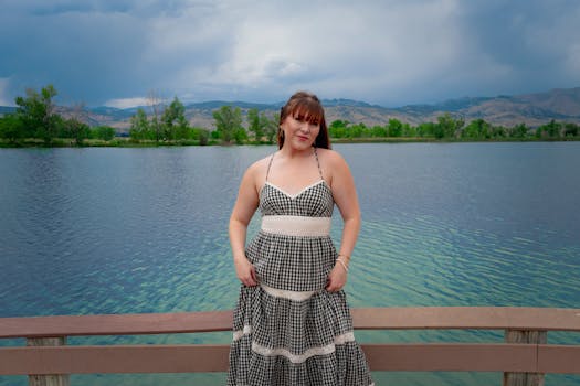 Portrait of a woman in a gingham dress by a serene mountain lake in Boulder, Colorado.
