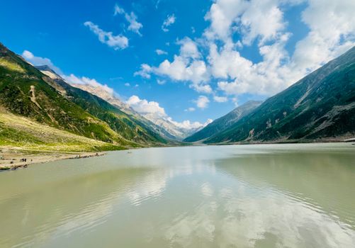 Breathtaking view of a serene lake surrounded by majestic mountains in Naran, Pakistan.