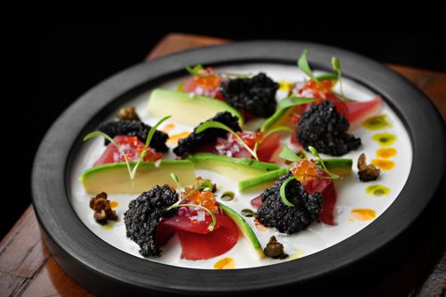 Free A beautifully presented gourmet dish featuring avocado, tuna, caviar, and fresh herbs. Stock Photo